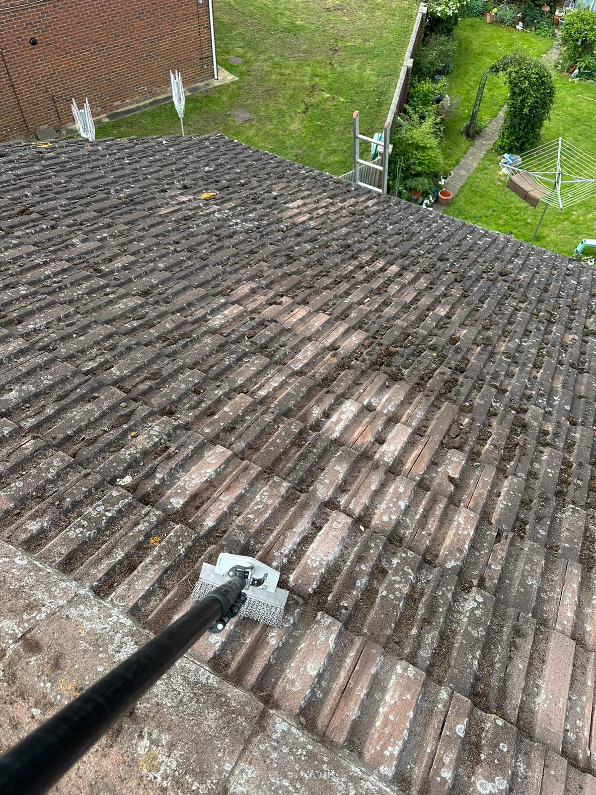 roof tiles being cleaned with metal scraper