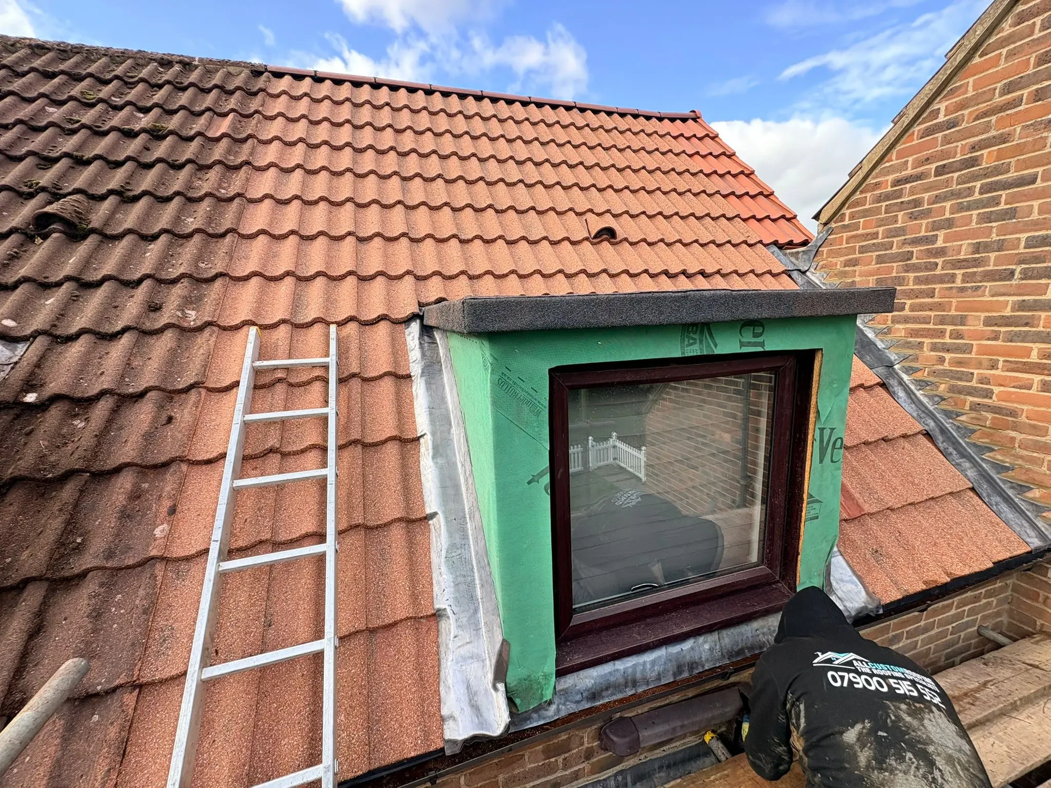 All Custom Roofing roofer fitting a dormer window into a tiled roof during a loft conversion