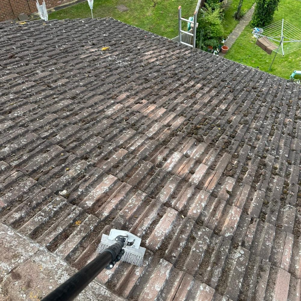 roof tiles being cleaned with metal scraper